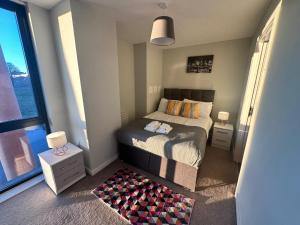 Habitación pequeña con cama y ventana grande. en Adelphi Wharf Apartments by Beehosting en Mánchester