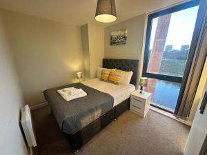 a small bedroom with a bed and a window at Adelphi Wharf Apartments by Beehosting in Manchester