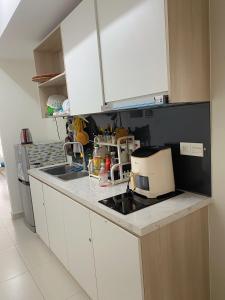 a kitchen with white cabinets and a counter top at Topaz twin in Bien Hoa