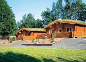 a large log cabin with a grass roof at Beech Hedge in Coupar Angus