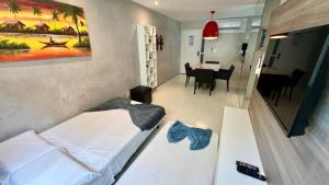 um pequeno quarto com 2 camas e uma sala de jantar em EDF SEVILHA - Apartamento com 1 suíte climatizada e 2 Banheiros, Sala Climatizada a 300 metros da Beira-Mar de Ponta Verde - EXCELENTE LOCALIZAÇÃO em Maceió