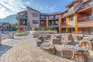 a courtyard with stone benches in front of a building at Best Views of Canmore - 2Bed 2Bath in Canmore