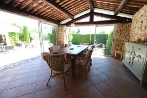 comedor con mesa de madera y sillas en Very pleasant vacation rental with heated pool in the Luberon, en Gargas