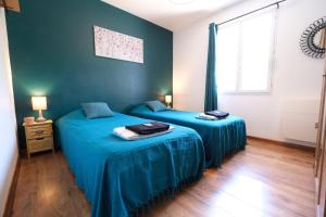 2 camas en una habitación con paredes azules en Very pleasant vacation rental with heated pool in the Luberon, en Gargas