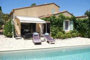 una casa con 2 tumbonas y una piscina en Very pleasant vacation rental with heated pool in the Luberon, en Gargas