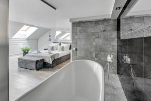 uma casa de banho com uma cama e uma banheira num quarto em Waterlane Riverside SPA, Pool & Gym by Downtown Apartments em Gdansk