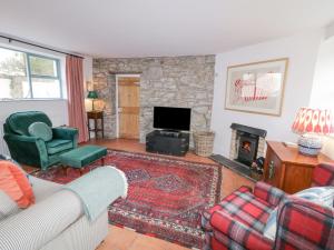 a living room with a couch and a fireplace at The Old Rectory Coach House in Rathmullan