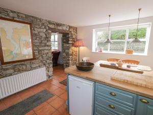 a kitchen with a counter and a stone wall at The Old Rectory Coach House in Rathmullan