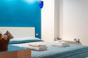a bedroom with two beds and a blue wall at B&B Scarabeo Milazzo in Milazzo