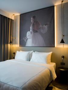 a bedroom with a bed with a large painting on the wall at Radisson RED Belgrade in Belgrade