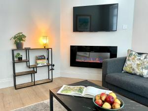 a living room with a couch and a fireplace at The Cottage Central Newcastle, 4-Star Accommodation by Tourism Northern Ireland in Newcastle