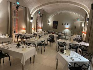 un comedor con mesas y sillas con mantel blanco en Hôtel Cloitre Saint Louis Avignon, en Aviñón