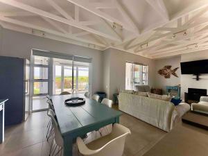 ein Wohnzimmer mit einem Tisch und einem Sofa in der Unterkunft Lodge 62 Unparalleled view. in Mossel Bay