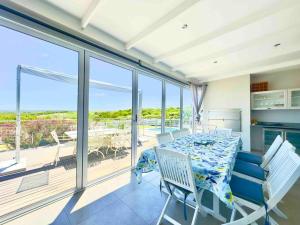 Mossel Bay的住宿－Lodge 62 Unparalleled view.，一间配备有桌子的海景用餐室