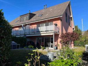 een groot roze huis met een groot balkon bij Gemütliches Haus in Knonau in Knonau