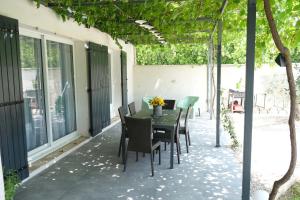 un patio con mesa y sillas. en very pleasant house with swimming pool in mouriès, near Les baux de provence in the alpilles – 6 people en Mouriès