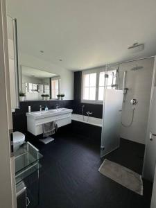een badkamer met een bad, een wastafel en een douche bij Gemütliches Haus in Knonau in Knonau