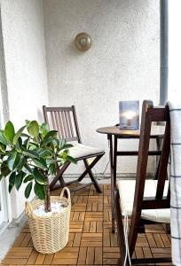 a porch with two chairs and a table with a potted plant at Zentrale Lage - Ideal für Arbeit & Erholung in Graben-Neudorf