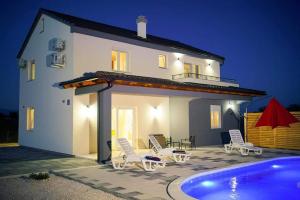 a villa with a swimming pool at night at Villa Fiore in Žarović