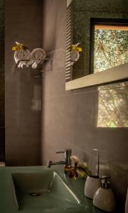 a bathroom with a green sink and a mirror at Bairos House - Coastal Escape in Ribeira Brava