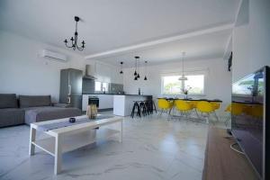 a living room with a couch and a table and yellow chairs at Villa Fiore in Žarović