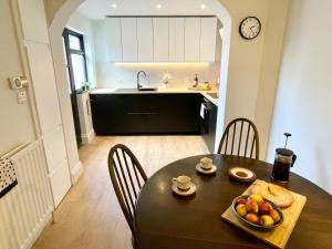 a kitchen with a table with a bowl of fruit on it at The Cottage Central Newcastle, 4-Star Accommodation by Tourism Northern Ireland in Newcastle +12 photos