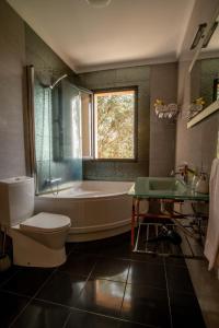 a bathroom with a tub and a toilet and a sink at Bairos House - Coastal Escape in Ribeira Brava