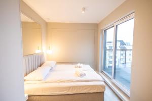 - une chambre avec un lit et une grande fenêtre dans l'établissement Apartament Lotników, à Toruń