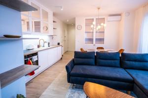 Il comprend un salon avec un canapé bleu et une cuisine. dans l'établissement Apartament Lotników, à Toruń