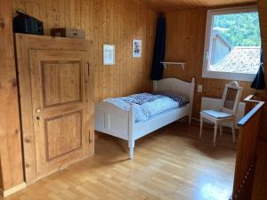 Habitación pequeña con cama y ventana en Appartamento Evelina, en Airolo