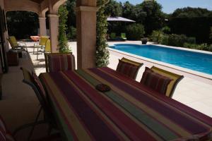 Aureilleにあるpleasant villa located in aureille, close to the center by foot, in the alpilles park, sleeps 6.のスイミングプールの横のテーブルと椅子