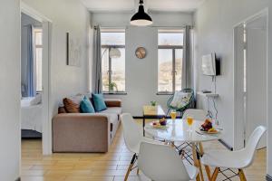 a living room with a couch and a table and chairs at The Heriot City Centre Apartments in Cape Town