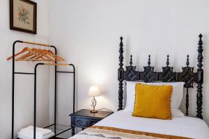 a bedroom with a black and white bed with a yellow pillow at Sé Heritage in Angra do Heroísmo