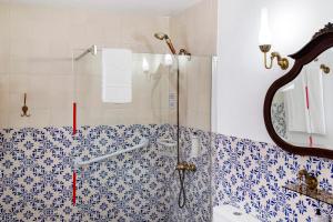 a bathroom with a shower with blue and white tiles at Sé Heritage in Angra do Heroísmo