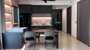 ルムットにあるGrand’e La Villa Homestayのテーブルと椅子4脚付きのキッチン