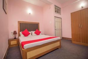 ダージリンにあるHotel North Point Darjeeling - Excellent Service Recommended & Couple Friendlyのベッドルーム1室(大型ベッド1台、赤い枕付)