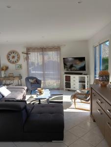 ein Wohnzimmer mit einem Sofa und einem Tisch in der Unterkunft Maison au calme et proche de la mer in Arzal