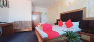 1 dormitorio con 1 cama con silla roja en Hotel North Point Darjeeling - Excellent Service Recommended & Couple Friendly, en Darjeeling