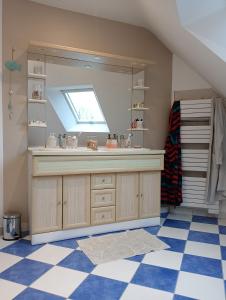 ein Bad mit einem Waschbecken und einem Spiegel in der Unterkunft Maison au calme et proche de la mer in Arzal