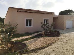 Eine Katze, die vor einem Haus sitzt in der Unterkunft very pretty contemporary villa with heated pool located in aureille in the alpilles, close to the center on foot. sleeps 4. in Aureille