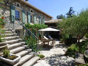 kamienny dom ze schodami, stołem i parasolem w obiekcie Semi-detached provencal farm with swimming pool w mieście Orgon