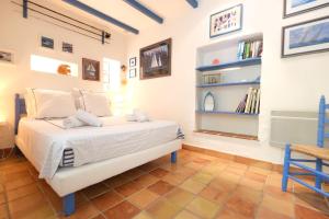 sypialnia z łóżkiem i półkami na książki w obiekcie Semi-detached provencal farm with swimming pool w mieście Orgon