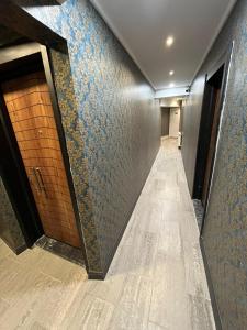 a hallway with blue and gray walls and a brown door at GRAND LOFT OTEL in Bursa