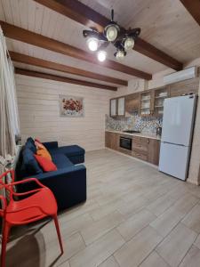 ein Wohnzimmer mit einem blauen Sofa und einem Kühlschrank in der Unterkunft КОТТЕДЖ У МОРЯ in Tschornomorsk