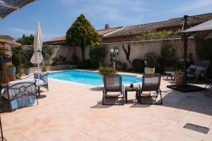 a patio with chairs and a swimming pool at pleasant home with private pool and pool house - close to aix en provence, accommodates 4 people. in Aix-en-Provence