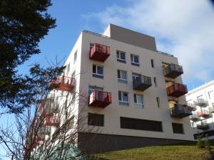 un edificio alto blanco con balcones rojos. en Apartmán Trilobit en Beroun