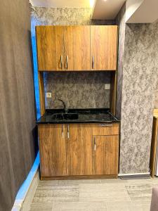 Una cocina con gabinetes de madera y un fregadero. en GRAND LOFT OTEL, en Bursa