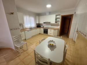 une cuisine avec une table et des chaises blanches ainsi qu'une table et des chaises blanches dans l'établissement Gran villa en Torremolinos, à Torremolinos