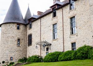 an old castle with turrets on a green lawn at Château du Bertry in La Bouexière