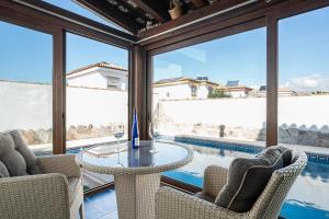 a patio with a table and chairs and a pool at Estribor 25 in Novo Sancti Petri